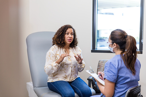 The female patient talks to the doctor about the symptoms she has been experiencing.