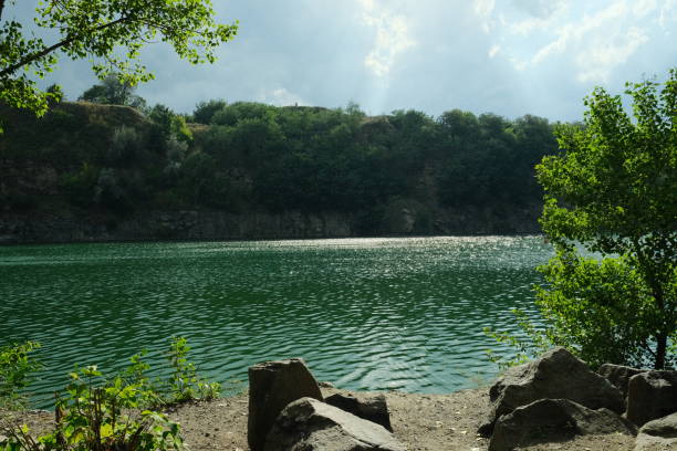 istock Sunny day at an artificial quarry with emerald water. A beautiful location for a picnic 1419973857