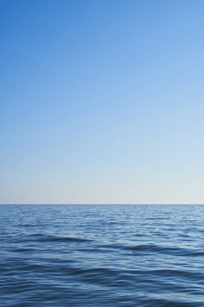 istock Dark blue water from the sea with blue sky. Light comes from the right. Vertical format, also suitable as a poster or background. Free space for text or objects. 1419974094
