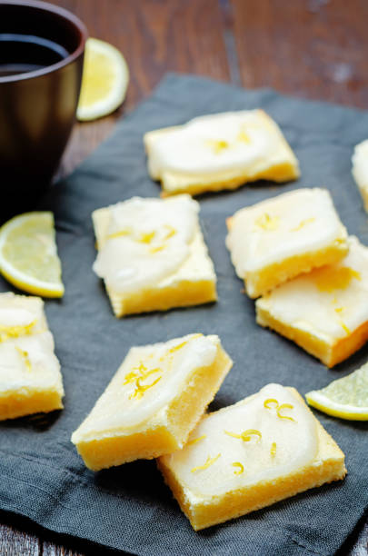 istock Lemon bars with lemon icing on a wood background 1419976797