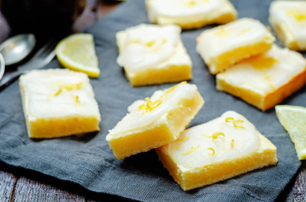 istock Lemon bars with lemon icing on a wood background 1419976866