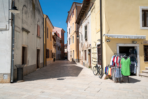 Traditional architecture of coast city street with small clothes store on street near coast in Croatia. This one is in Fazana, Istria in Croatia.