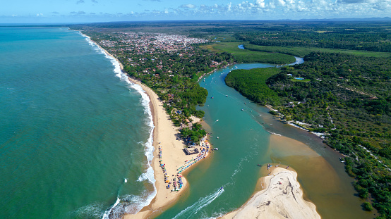 Aerial view of Caraiva beach, Porto Seguro, Bahia, Brazil. Colorful beach tents, sea and river.