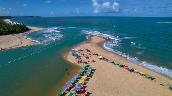 Aerial view of Caraiva beach, Porto Seguro, Bahia, Brazil. Colorful beach tents, sea and river.