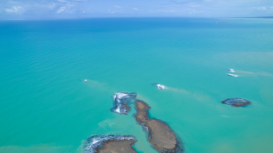 Aerial view of Praia do Espelho, Porto Seguro, Bahia, Brazil. Natural pools in the sea, cliffs and greenish water.