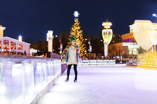 Young woman ice skating at Christmas