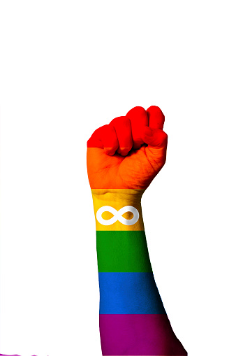 Rainbown flag with Autistic Pride sign painted on human raised fist. Strength, power, social concept. Raised fist. Autistic Pride