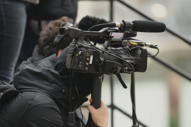 istock Videographer holding a video camera with microphone 1419982784