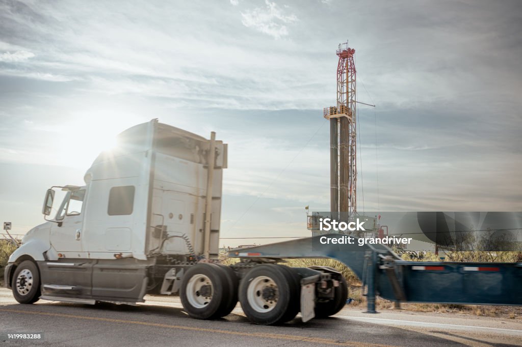 Dracking Drilling Rig Creating Gas or Oil Well Silhouetted at Dusk Under a Dramatic Sunset Sky North Dakota Stock Photo