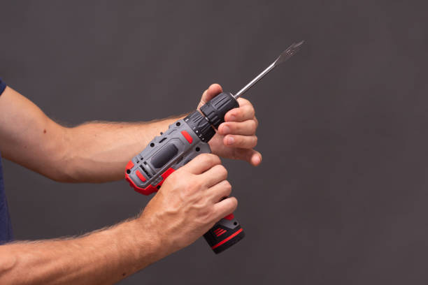 istock battery electric drill with a feather drill on wood. 1419984183