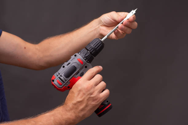 istock electric screwdriver with a wood drill in his hands on a black background 1419984185