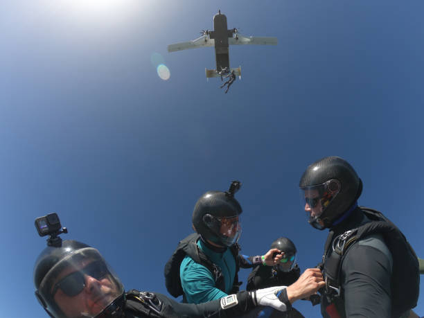 i paracadutisti cadono dall'aereo sopra, in volo aereo - skydiving parachuting extreme sports airplane foto e immagini stock