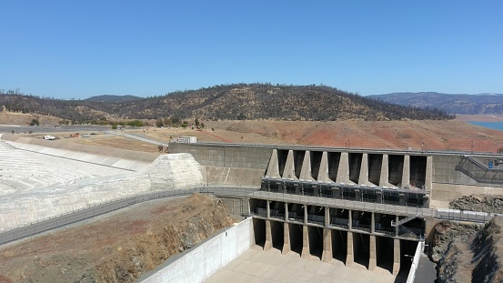 Lake Oroville Dam And Spillway after repairs were completed. Background is Lake Oroville during extreme drought.