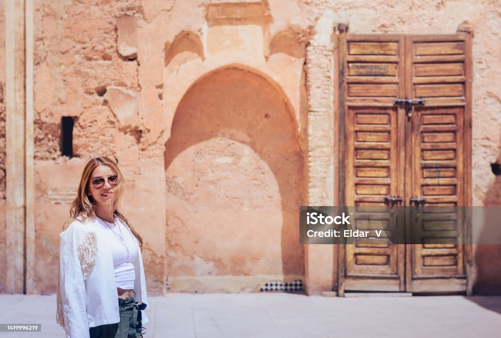 woman in morocco palace latin woman in a palace in morocco, in the background there is a wooden door, and a dead end. Admiration Stock Photo