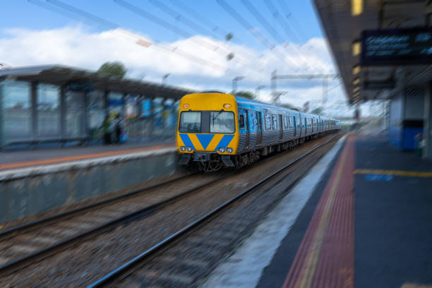 Commuter train approaching a train station in Melbourne Victoria Australia Commuter train approaching a train station in Melbourne Victoria Australia car hauling stock pictures, royalty-free photos & images