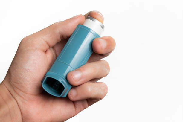 istock Holding an asthma inhaler on white background with copy space 1419999914