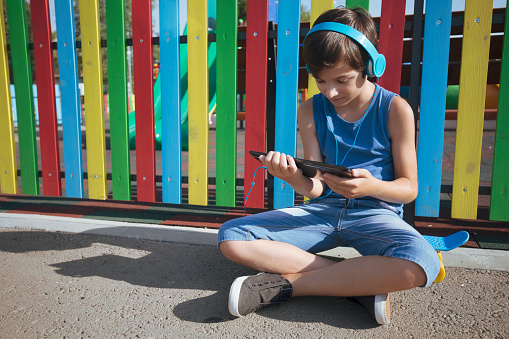 Child playing video games on sport playground
