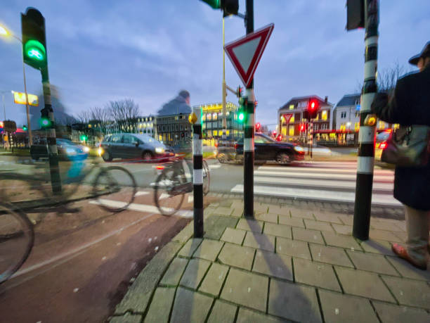 cyclist and crossing traffic intersection at night stock photo