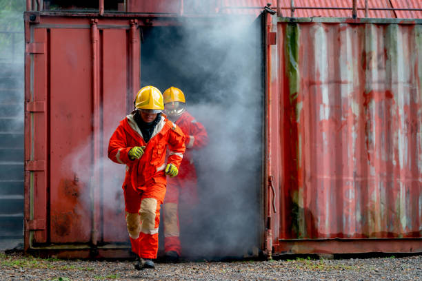 istock Two firefighter men run out from room cover with huge smoke after fire occur inside the building. 1420017094