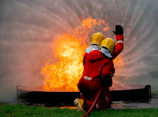 istock Back of firefighter team support together to distinguish fire using water curtain to control area of fire. 1420017125