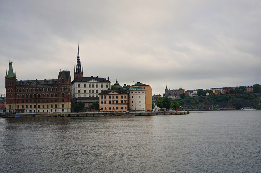 view of buildings by river against cloudy sky