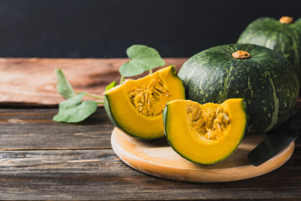 istock Green pumpkin on wooden background 1420022801