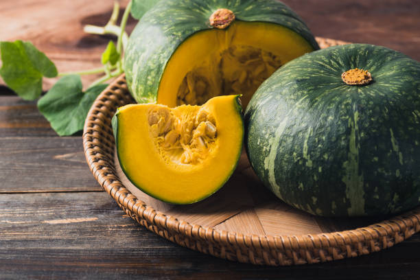 istock Green pumpkin in basket on wooden background 1420022810