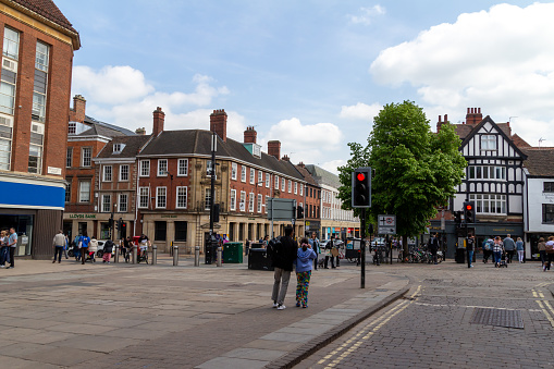 Road Sign in Sevenoaks High Street, England, with stores and restaurants visible in the background, and a person walking on the right.