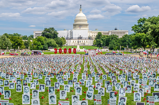 30000 pictures of iranian people killed planted on lawn in front of the Washington Capitol during summer day
