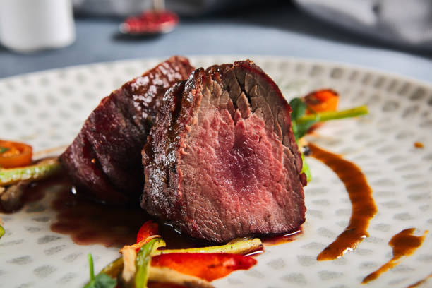 istock Roasted Beef fillet with vegetables. Roasted Mignon steak with paprika and celery. Beef tenderloin with garnish. Beef steak medium rare doneness. Delicious meat menu. Dish concept with angus beef. 1420037763
