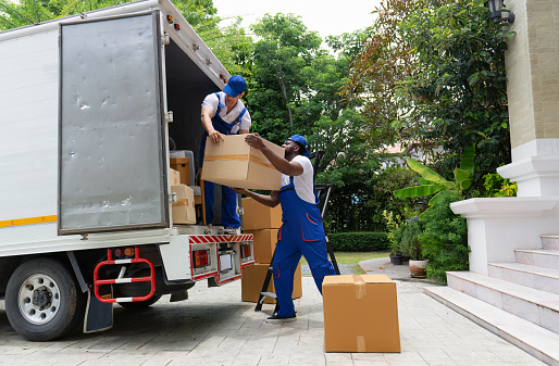Professional goods move service use truck carry personal belongings door to door transport delivery handover boxes luggage one by one and keep stack on the floor before transfer to place in house