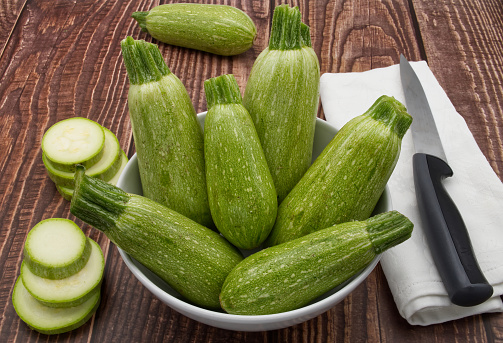 Raw fresh zucchini isolated on wooden background.