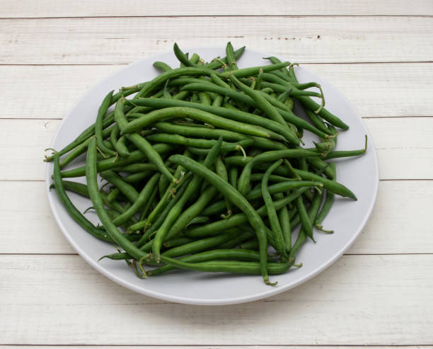 istock Raw green beans isolated on clear wooden background 1420049690