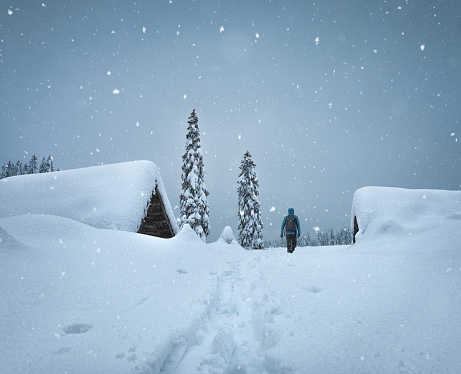 Man walking through the snowcapped mountain village on a beautiful winter day.