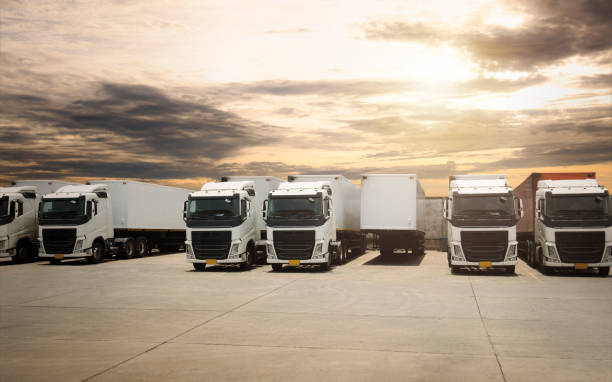 istock Semi TrailerTrucks Parked Lot with The Sunset Sky. Shipping Container. Delivery Transit. Engine Diesel Trucks. Lorry Tractor. Industry Freight Trucks Logistics Cargo Transport. 1420054499