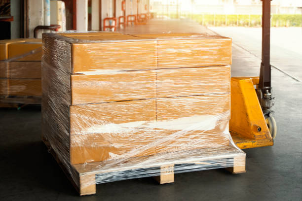 istock Packaging Boxes Wrapped Plastic Stacked on Pallets in Warehouse. Cartons Cardboard Boxes. Supply Chain. Storehouse Distribution. Cargo Shipping Supplies Warehouse Logistics. 1420054502