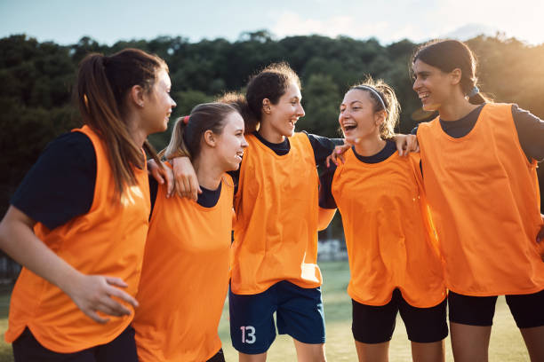 istock Cheerful female soccer team huddling while celebrating on playing field. 1420057071