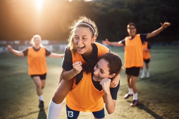 Victory is ours! Happy female players celebrating a goal during soccer match at the stadium, sport stock pictures, royalty-free photos & images