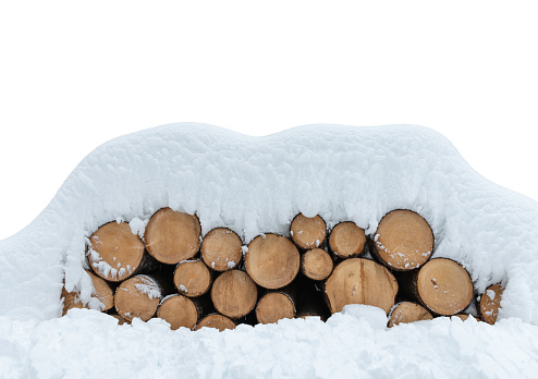 Stack of wooden logs covered with fresh snow on white background (cut out).