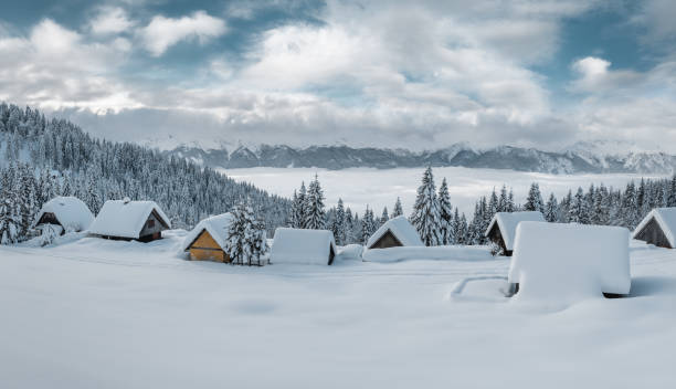 villaggio di montagna innevato - alpine upland foto e immagini stock