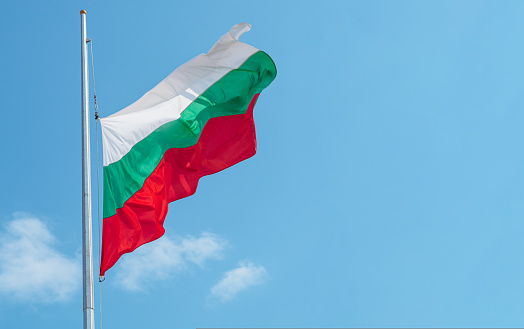 Flag of Bulgaria against the sky. Bulgarian flag with copy space for migration banner services for obtaining permanent residence, citizenship and a golden passport.