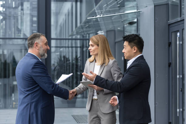 istock Three experienced managers team leaders, meet and get to know from outside the office team, diverse group of entrepreneurs shake hands men, introduce new colleague, 1420067917