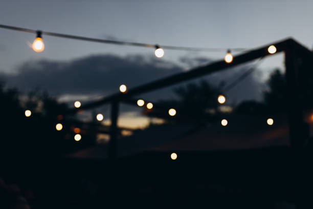 istock Decorative outdoor string lights at night time, Defocused Background, night city life backdrop, party time with Yellow bokeh balls 1420068098