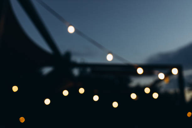 istock Decorative outdoor string lights at night time, Defocused Background, night city life backdrop, party time with Yellow bokeh balls 1420068127