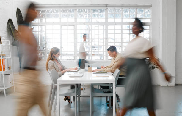 blurred designers, marketing or freelance professionals working together in a modern office. business men and women busy, walking and active in a creative workplace, workstation or environment - estúdio de design imagens e fotografias de stock