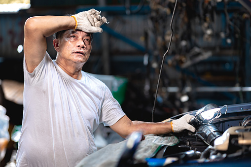 mechanic worker in garage auto service tired stressed hardwork fatigue hot workplace wipe sweat