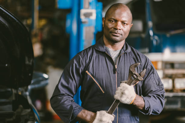 istock portrait Black African mechanic garage worker check auto service team staff smart standing confident 1420068745