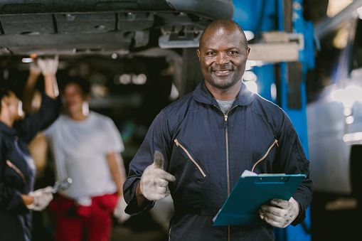 portrait Black African mechanic garage worker check auto service team staff smart standing happy smile