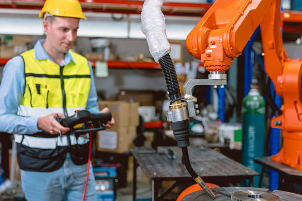 istock Worker man working with robot arm automate welding machine in modern metal factory. Engineer program robotic in heavy industry. 1420069252