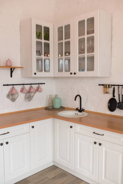 istock Wooden counter with white sink and utensils near light wall in kitchen 1420069528